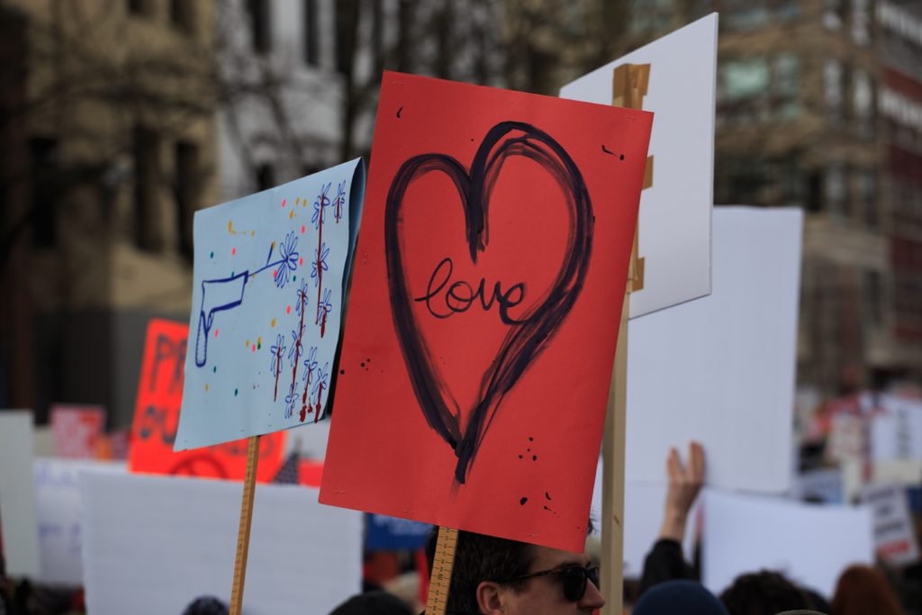 protest signs with one with a heart
